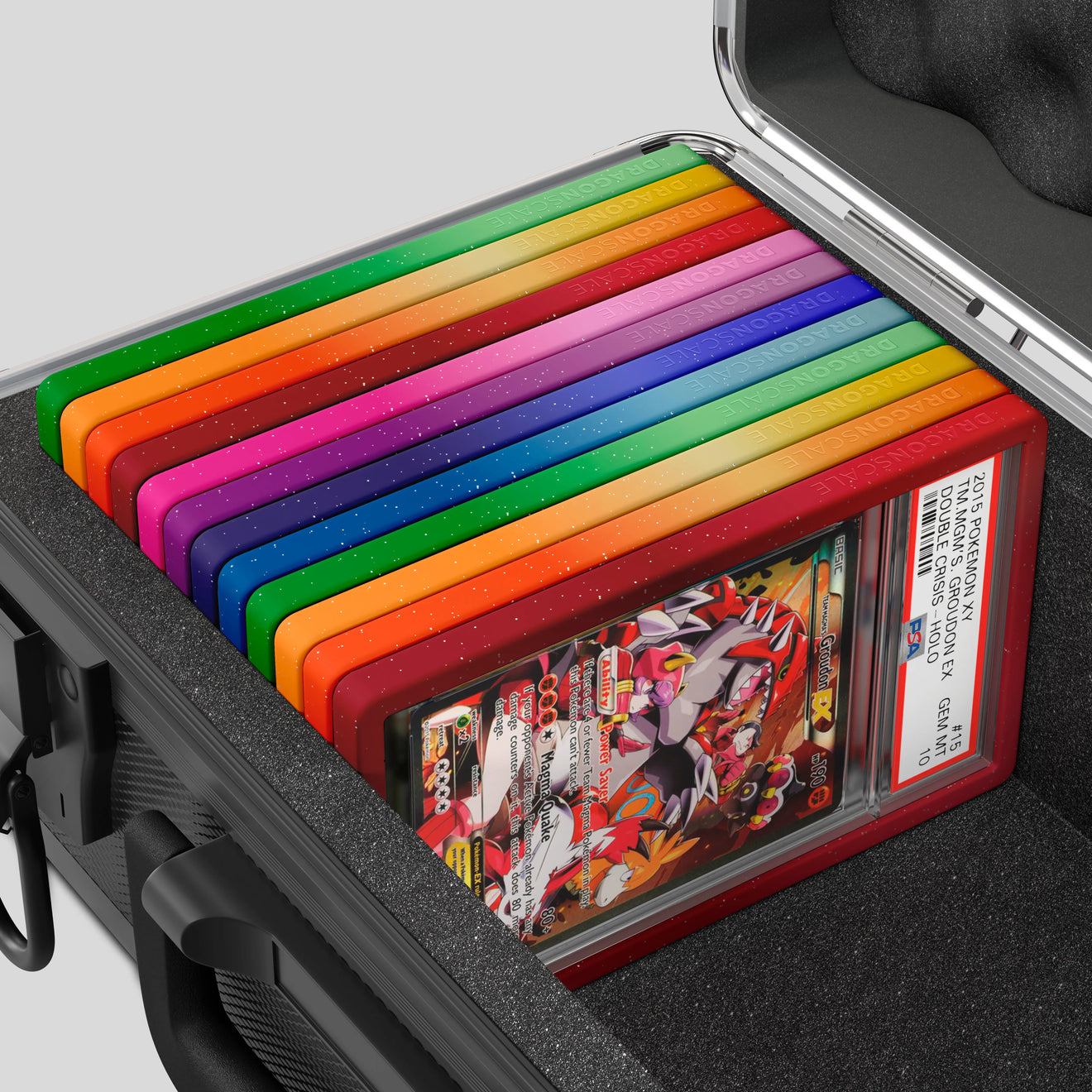 Close-up of the Dragonscale Basilisk X-40 Compact metal slab case in carbon black foam slot securely holding PSA slabs with Dragonscale guards.