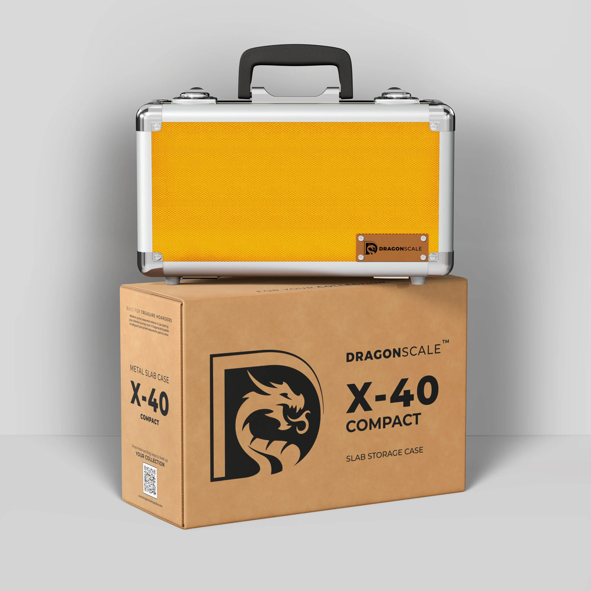 Display and demo view of the Dragonscale Basilisk X-40 Compact metal slab case in gold, placed on top of its branded cardboard packaging box.