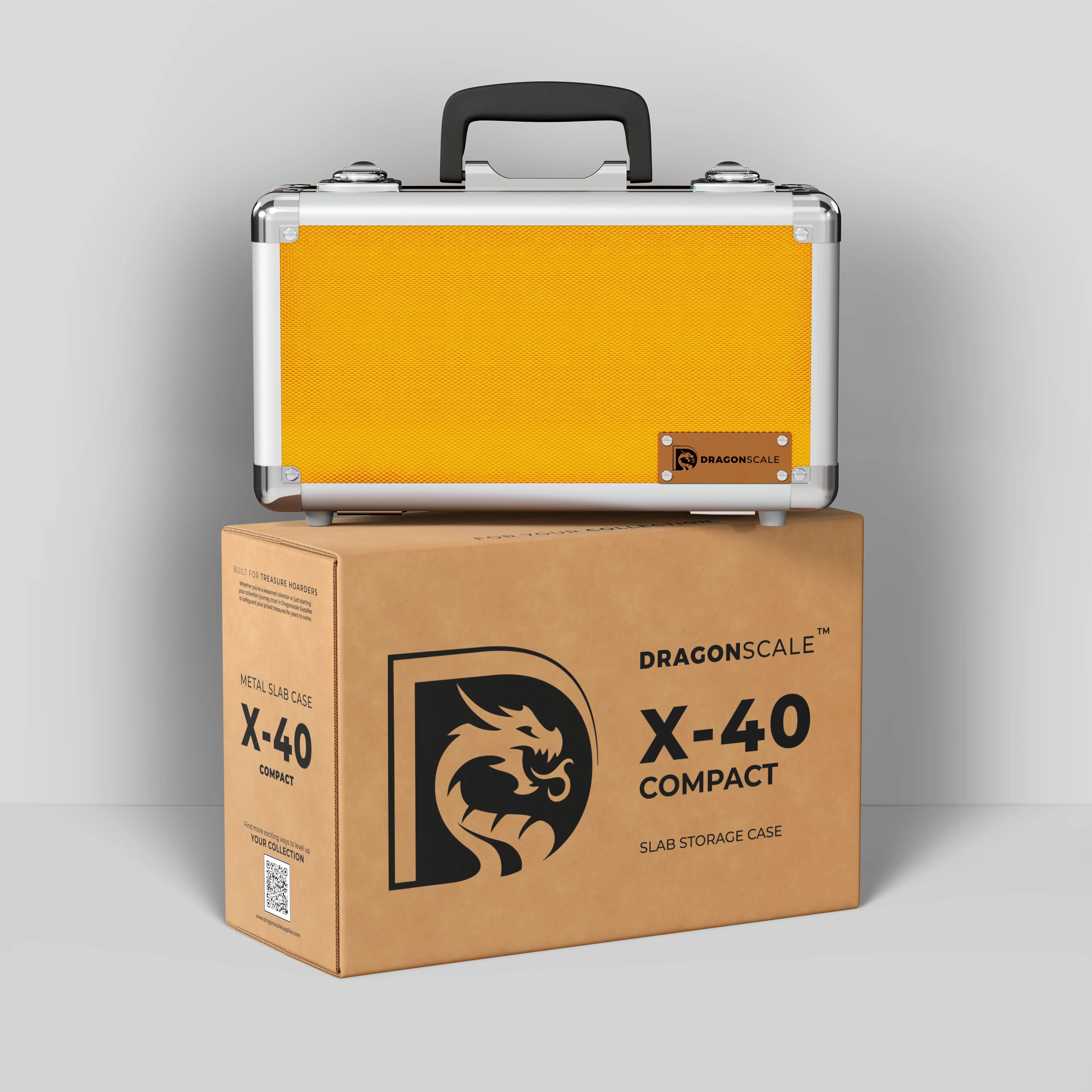 Display and demo view of the Dragonscale Basilisk X-40 Compact metal slab case in gold, placed on top of its branded cardboard packaging box.