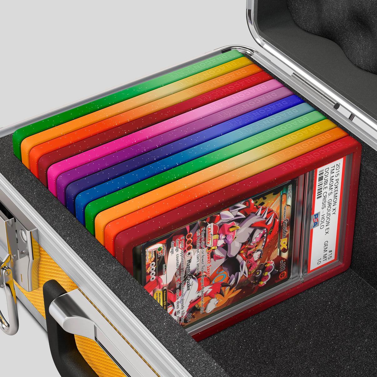 Close-up of the Dragonscale Basilisk X-40 Compact metal slab case in gold foam slot securely holding PSA slabs with Dragonscale guards.