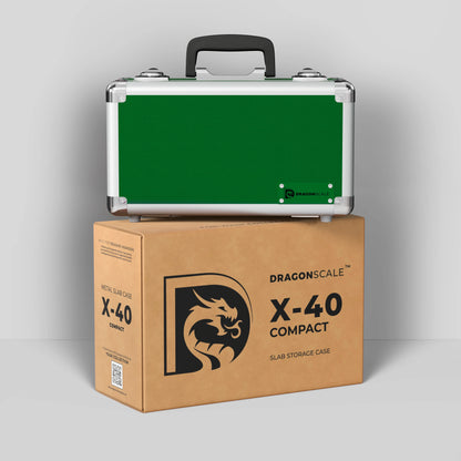 Display and demo view of the Dragonscale Basilisk X-40 Compact metal slab case in emerald green, placed on top of its branded cardboard packaging box.