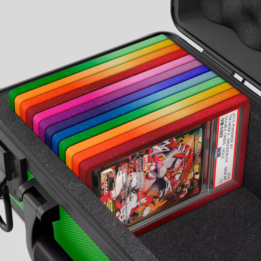 Close-up of the Dragonscale Basilisk X-40 Compact metal slab case in emerald green foam slot securely holding PSA slabs with Dragonscale guards.