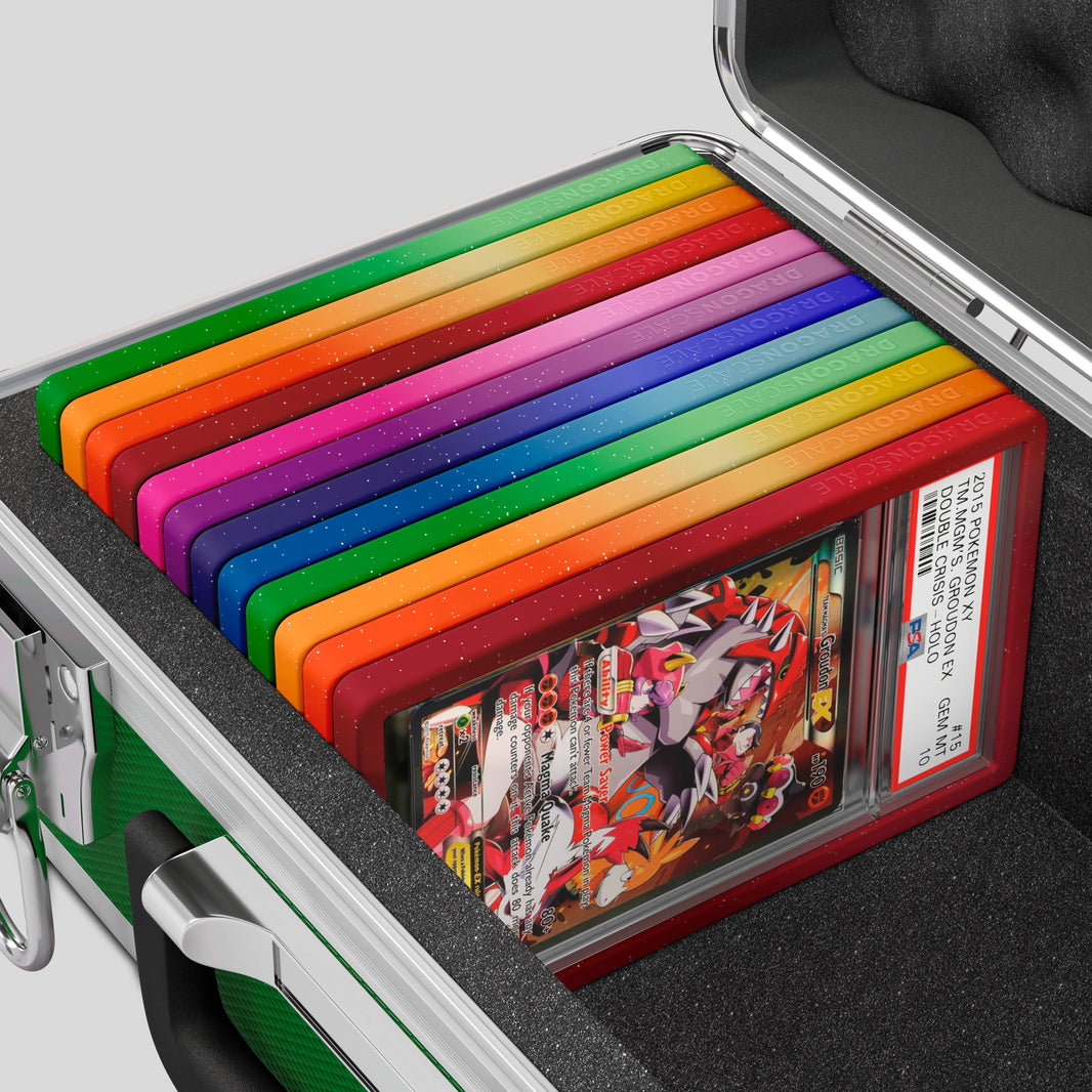 Close-up of the Dragonscale Basilisk X-40 Compact metal slab case in emerald green foam slot securely holding PSA slabs with Dragonscale guards.