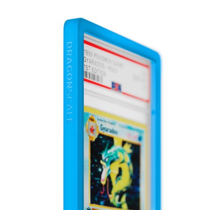 Close up logo zoom view of a PSA slab in Solid Cyan Dragonscale bumper guard, featuring a Gyrados 1st Edition Base Set PSA 10 Pokemon card.