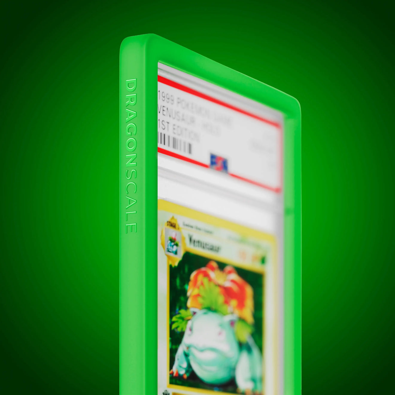 Close up logo zoom view of a PSA slab in Solid Green Dragonscale bumper guard, featuring a Venusaur 1st Edition Base Set PSA 10 Pokemon card.