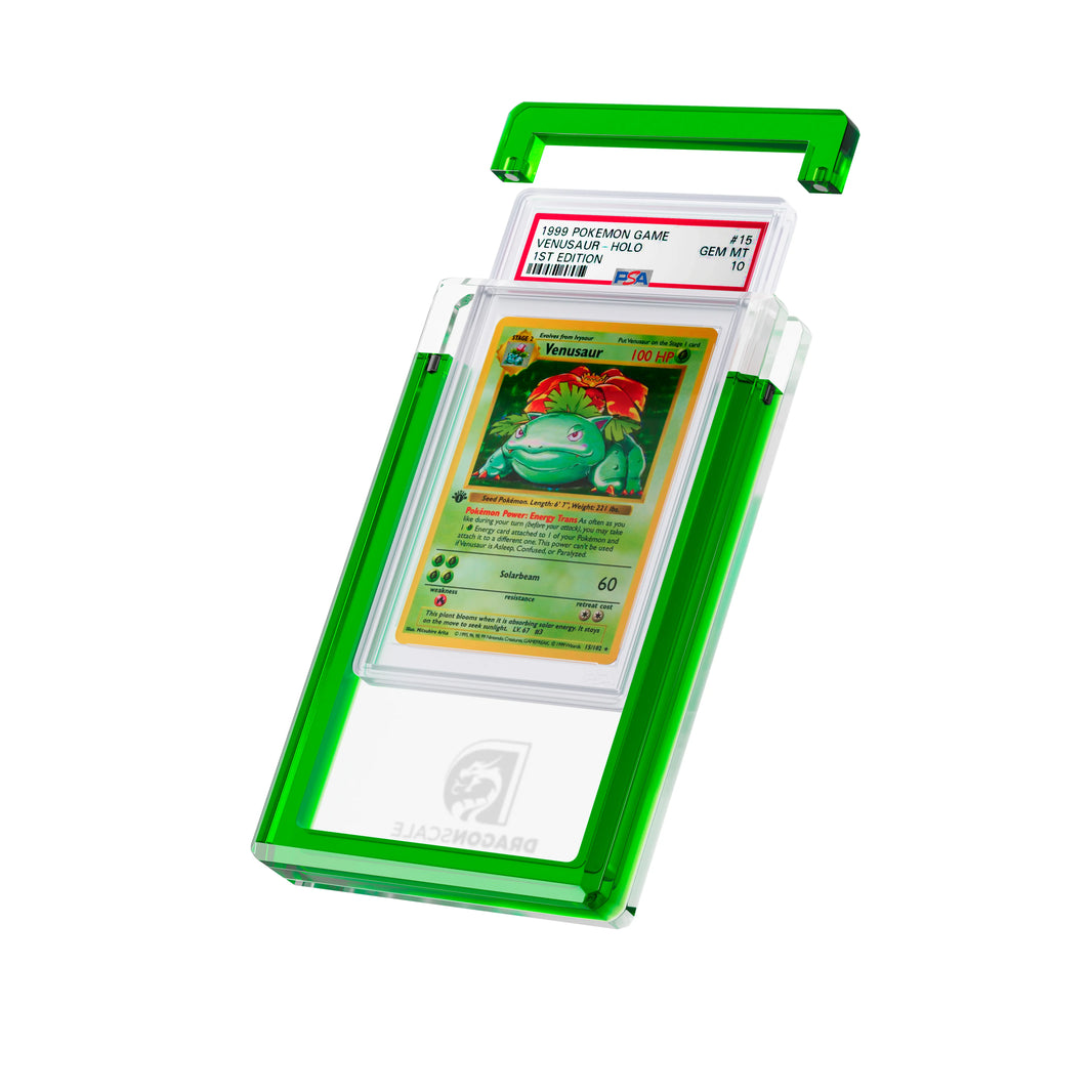 Angled display and demo view of the Dragonscale Wyrmgem Solid Emerald acrylic case, highlighting the acrylic lid and secure magnetic locks featuring a Venusaur 1st Edition Base Set PSA 10 Pokemon card.