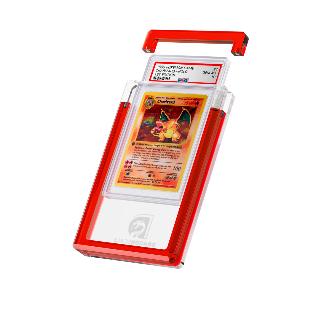 Angled display and demo view of the Dragonscale Wyrmgem Solid Ruby acrylic case, highlighting the acrylic lid and secure magnetic locks featuring a Charizard 1st Edition Base Set PSA 10 Pokemon card.